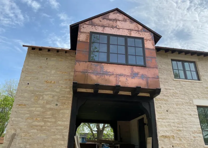 Copper metal panel facade on a stone building for Roof Repair in Verde Village