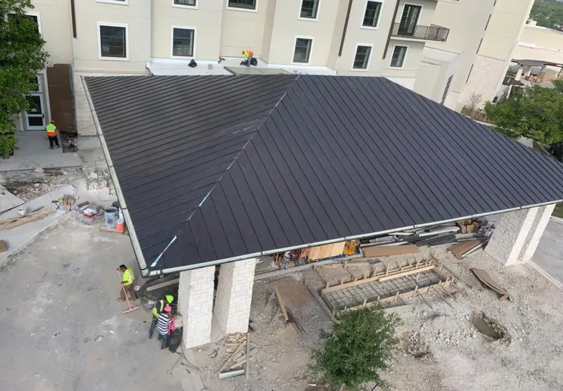 Metal roofing installation team working on a commercial building in Verde Village